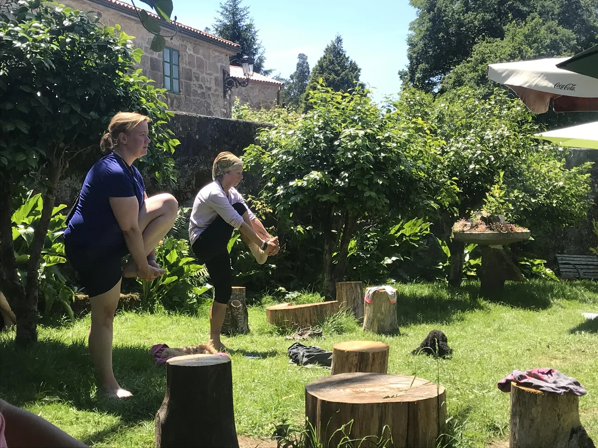 Pilgerinnen an einem Garten mit kleinen Holzpodesten.